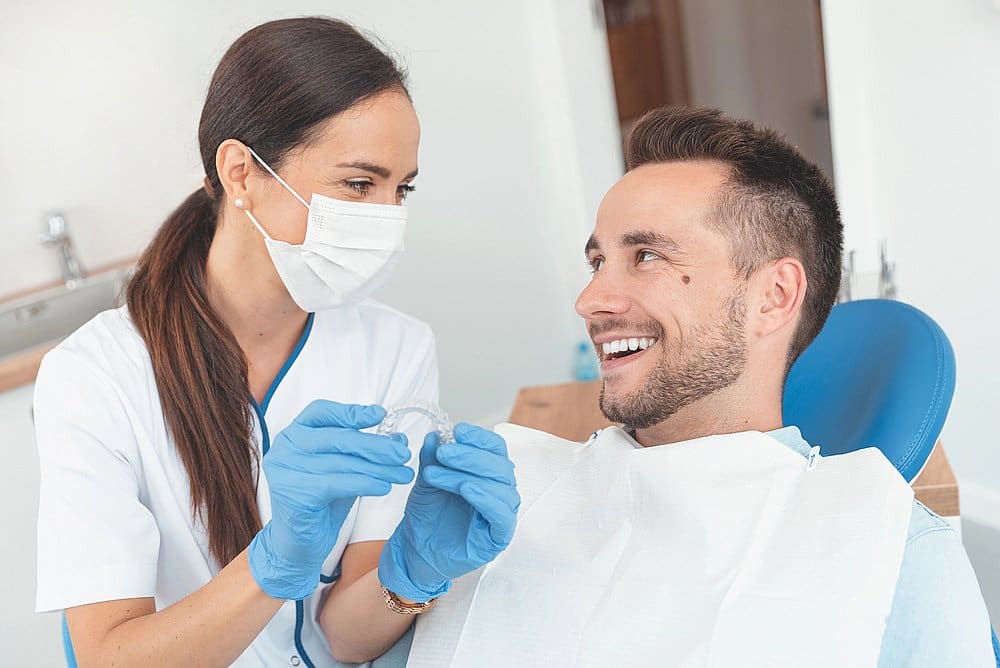 orthodontist from Wink Orthodontics in Prosper, TX showing Invisalign clear aligners to her patient