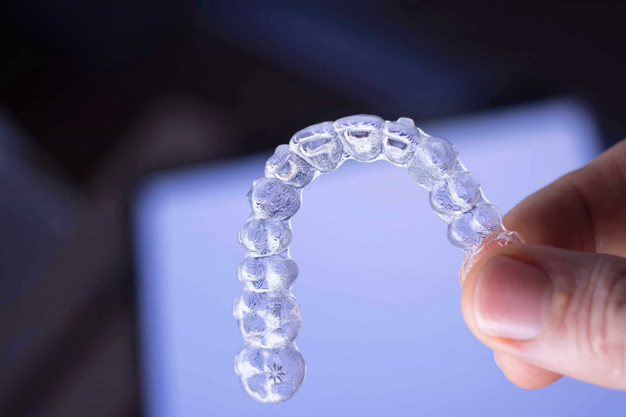 A hand holding a clear dental aligner suggest choose affordable invisalign with invisalign cost at Winks Orthodontics
in Prosper and Colleyville, TX
