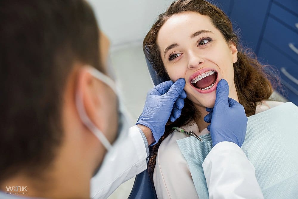 A patient having her teeth examined by a dentist, discussing options for how to fix overbite in Prosper and Colleyville TX.