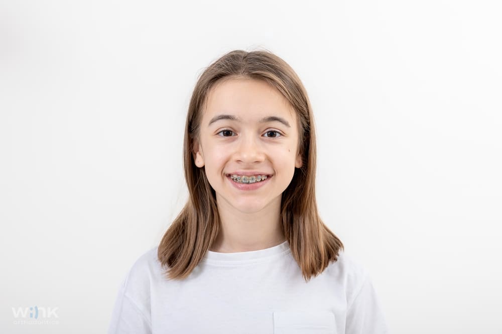 Portrait of a happy young girl with braces smiling highlighting braces for overbite in prosper and colleyville, tx