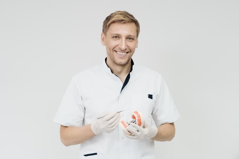 All PPO Insurance Plans Accepted: Orthodontist with Payment Plans Near You an Orthodontist in Prosper, TX holding a teeth model